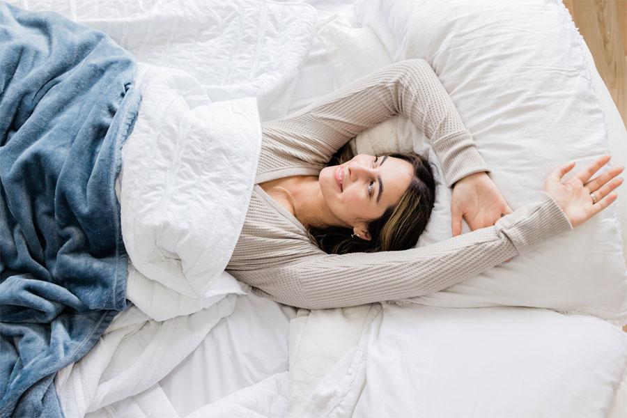 A beautiful young girl lying on her bed.