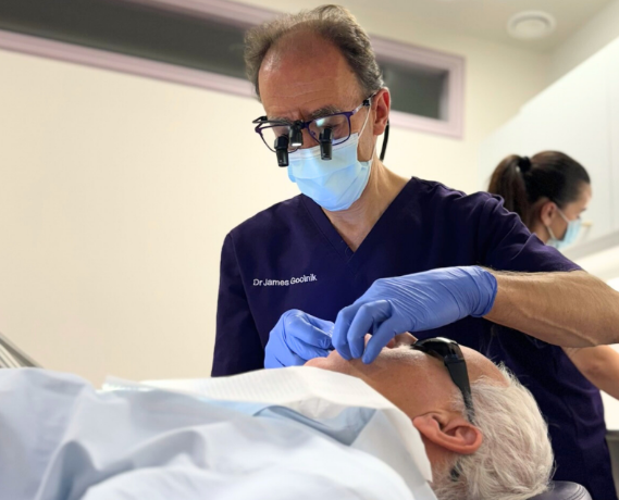 an image of dr james goolnik at optimal dental health treating a patient